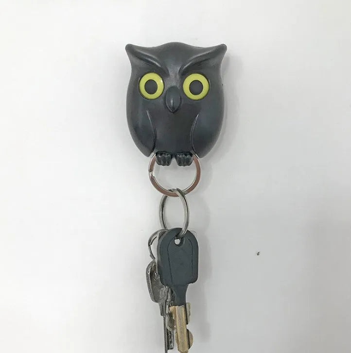 Magnetic wall key holder in white with attached keychains on a wall surface
