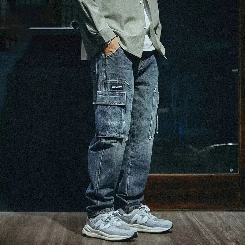Blue men's loose straight-leg stretch jeans with a zip fly on a neutral background.