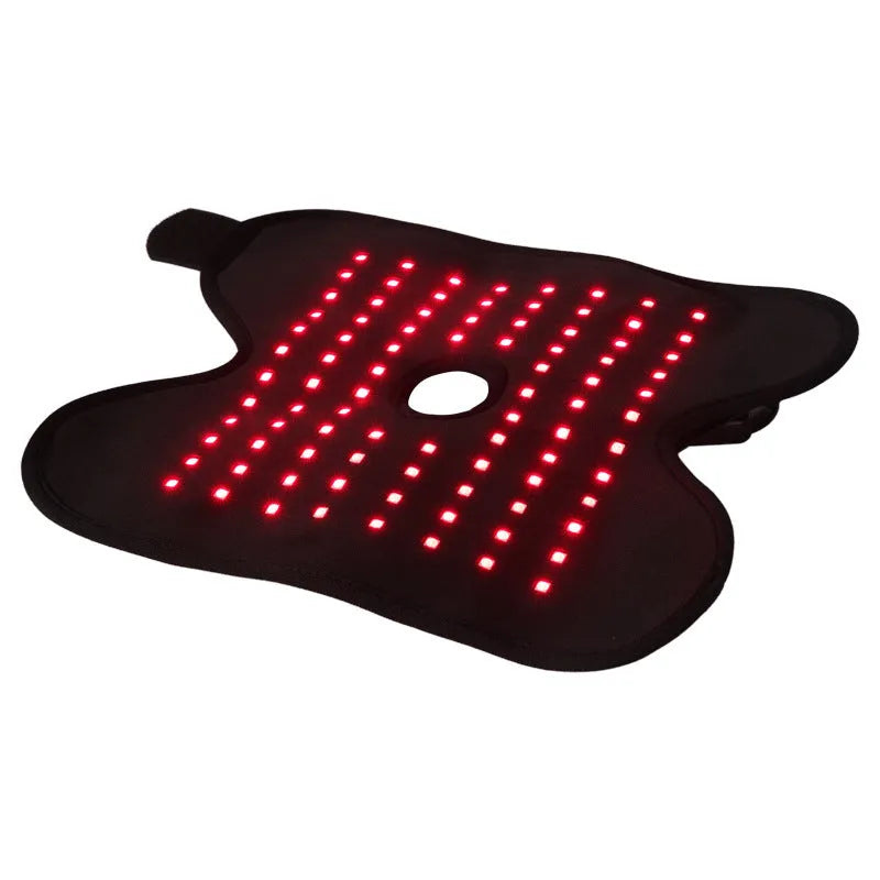 Black ankle heating wrap with red light therapy and USB cable on flat surface