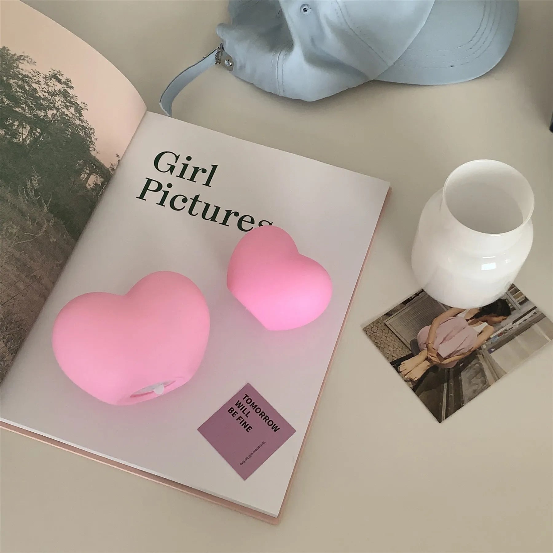 Small pink vinyl atmosphere lamp glowing with warm light on a wooden surface.