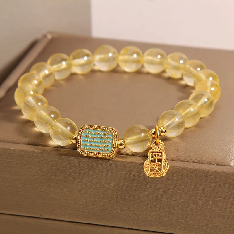 Women's citrine yellow crystal bracelet with rhinestone detailing on a wrist