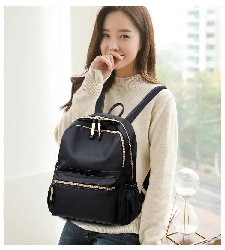 Black waterproof Oxford backpack for women, 34cm high, showing front view on plain background
