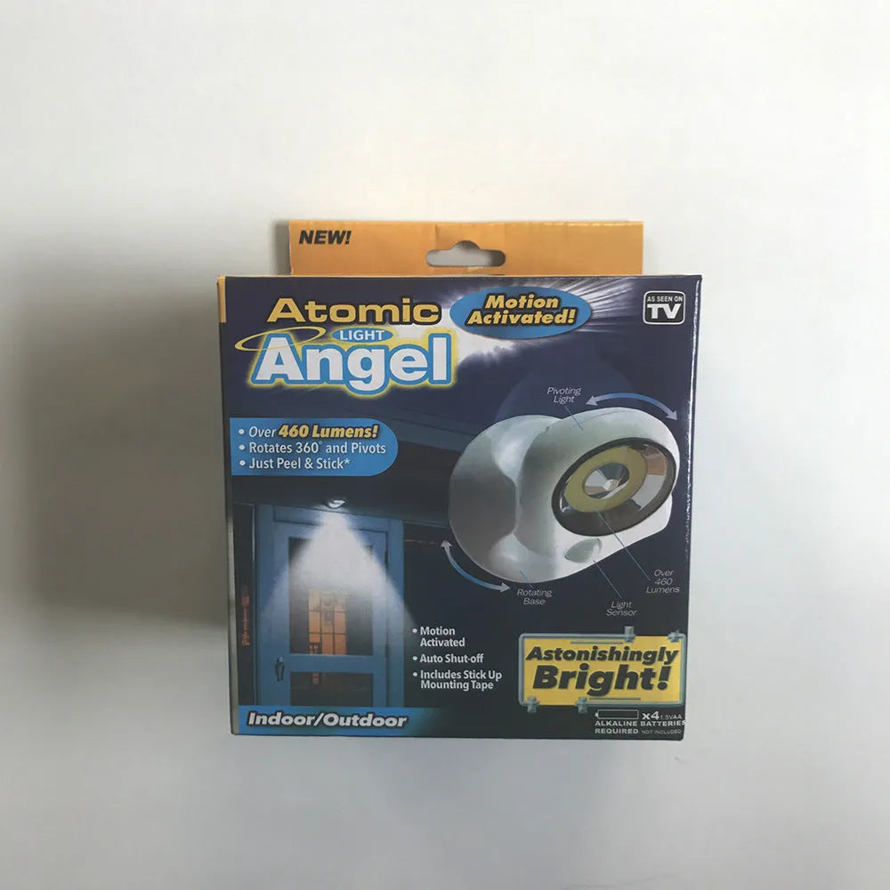 White Atomic Angel induction desk lamp with compact ABS plastic housing on a desk.