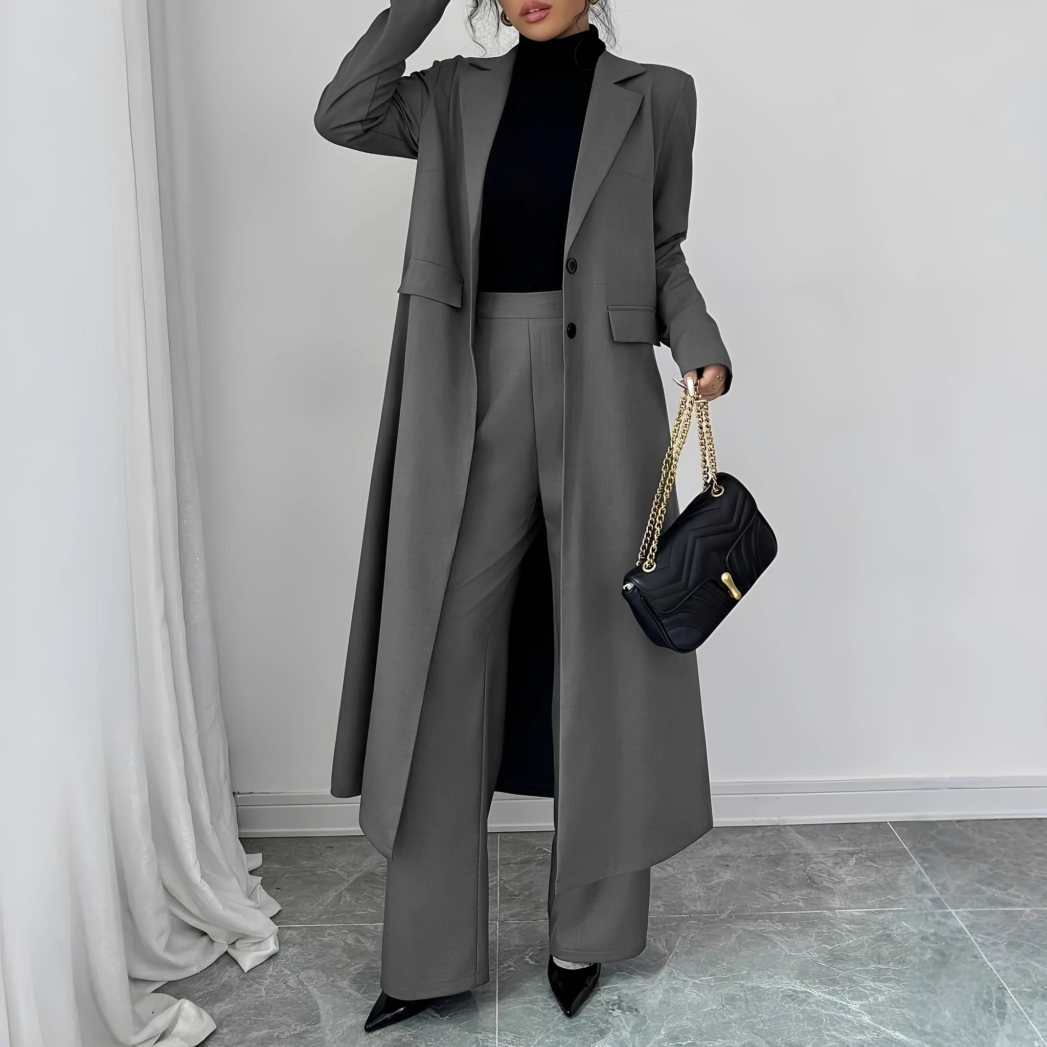 Women's gray polyester two-piece suit with long jacket and trousers on mannequin