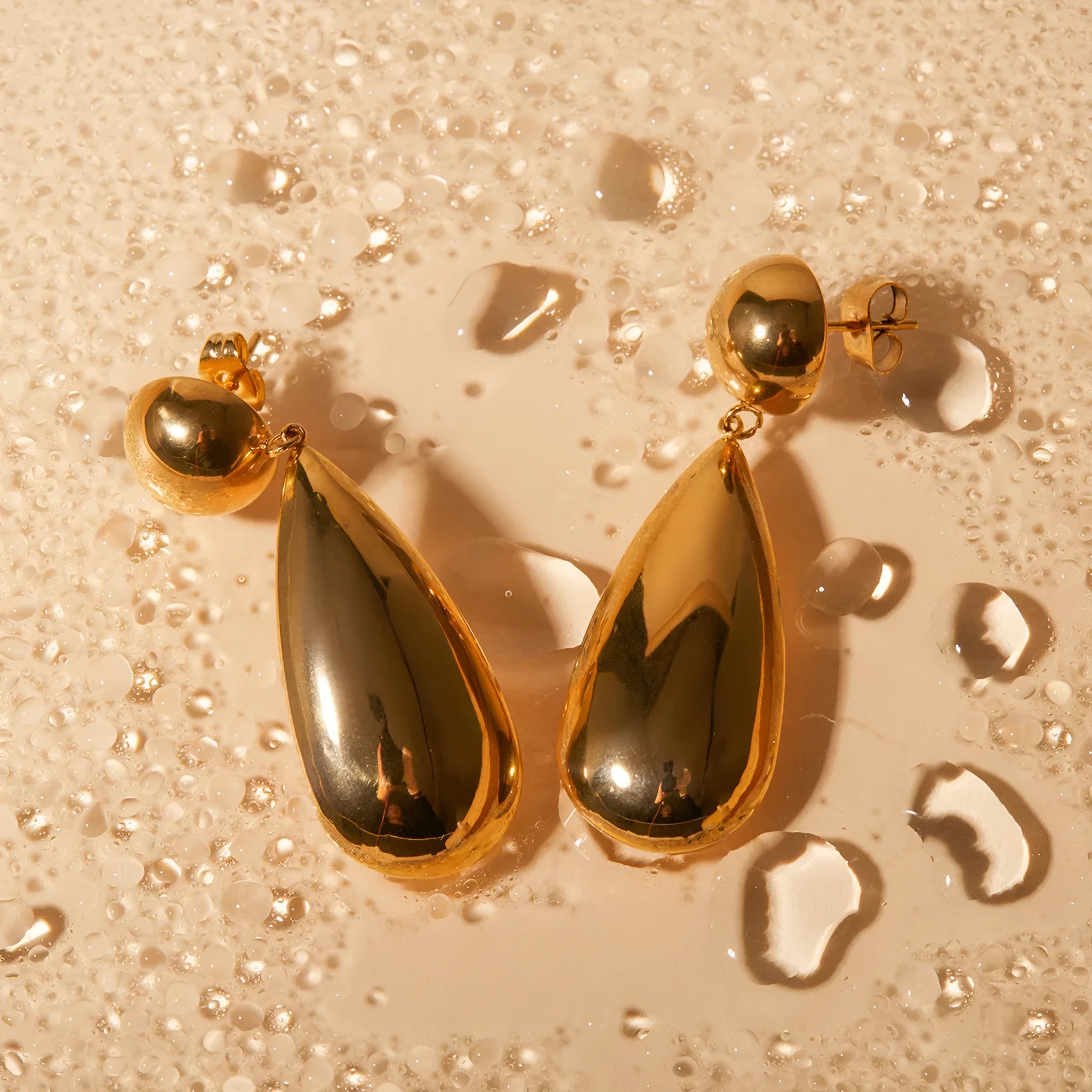 Gold electroplated stainless steel water drop earrings with geometric hemisphere design