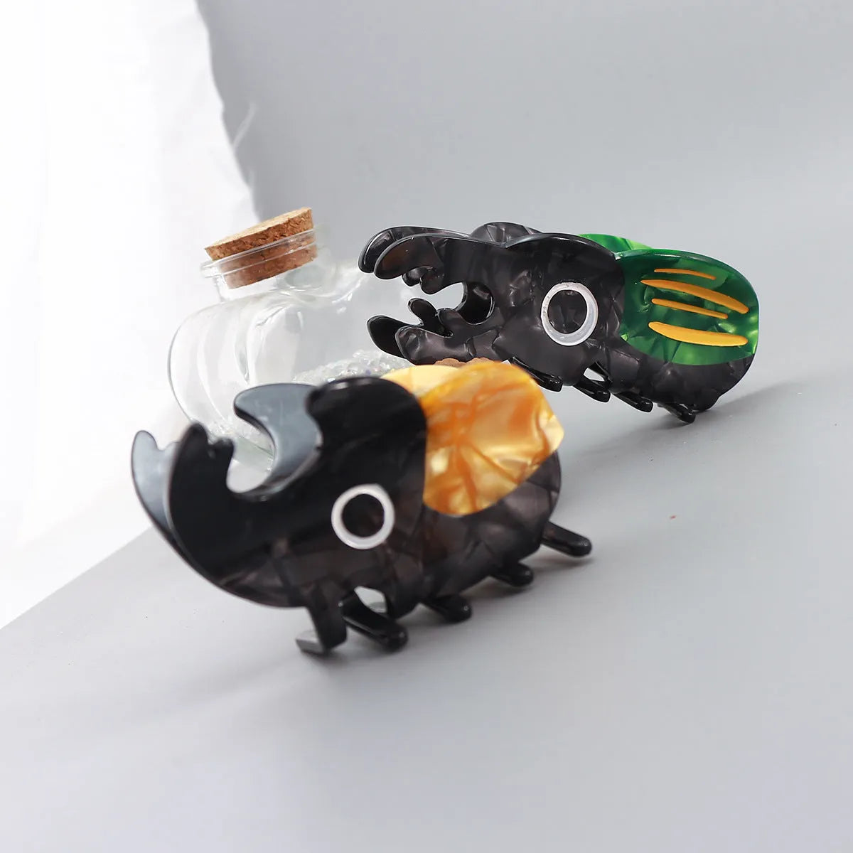 Handmade cellulose acetate beetle grip hair clip with cartoon caterpillar design in green, orange and white colours