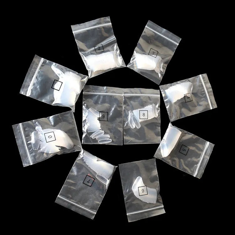 500 clear transparent false nails in 10 sizes arranged on a table, made from ABS plastic