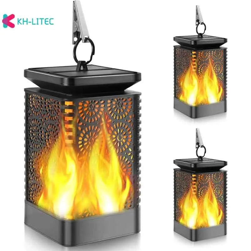 Set of four black solar-powered hanging lanterns with flickering flame LED lights for outdoor garden decoration.
