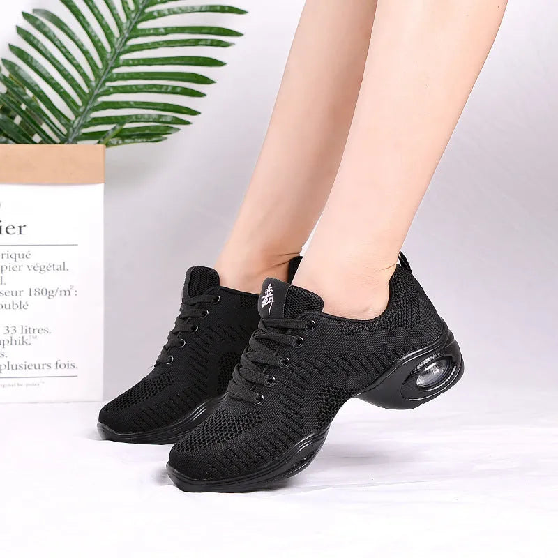 Women's white breathable mesh dance shoes with a lightweight PU sole on a studio floor.