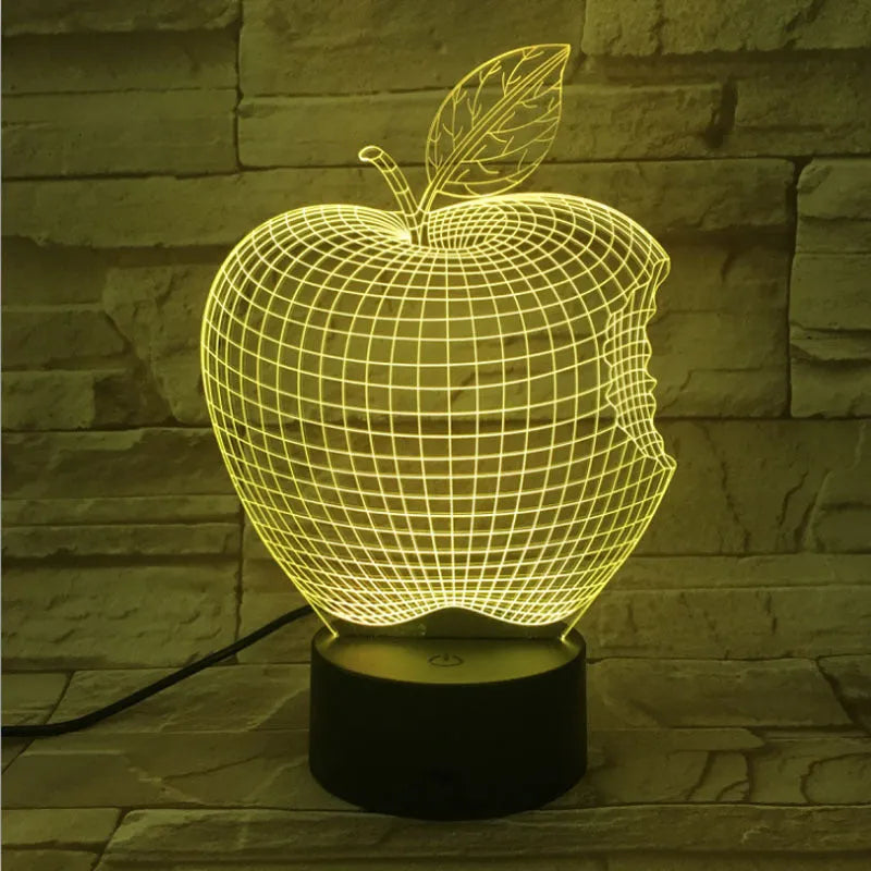 3D fruit-shaped colourful LED night light with touch control on a table.