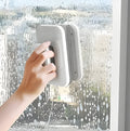 Magnetic double-sided window cleaner with silicone scraper on glass surface, 10x15x4cm size, white ABS body