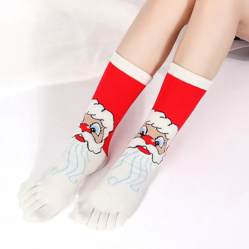 Christmas five finger socks with cartoon patterns in black, green, and white on a neutral background