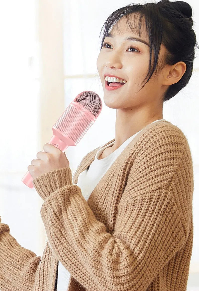 Wireless Bluetooth karaoke microphone in pink, blue, or green with USB port.