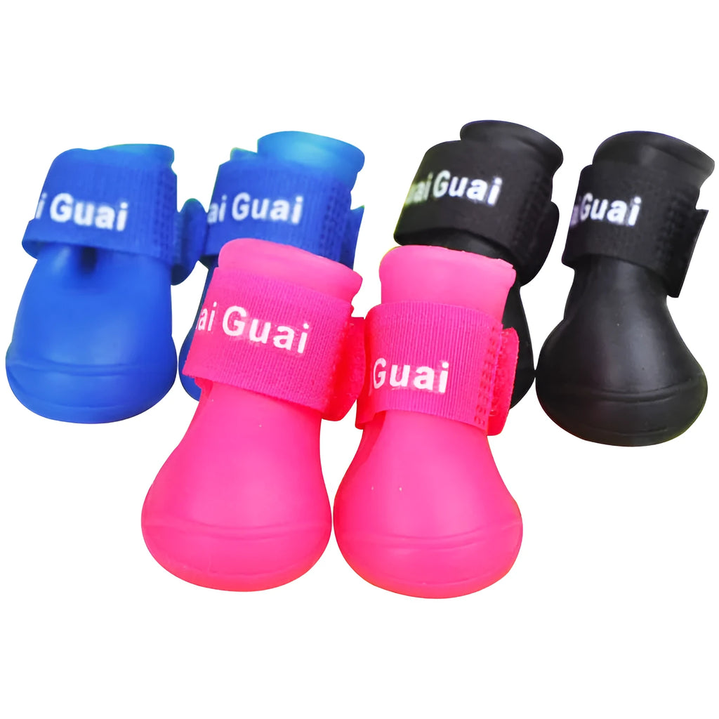 Soft silicone pet rain boots in royal blue on a wet pavement, non-slip sole visible