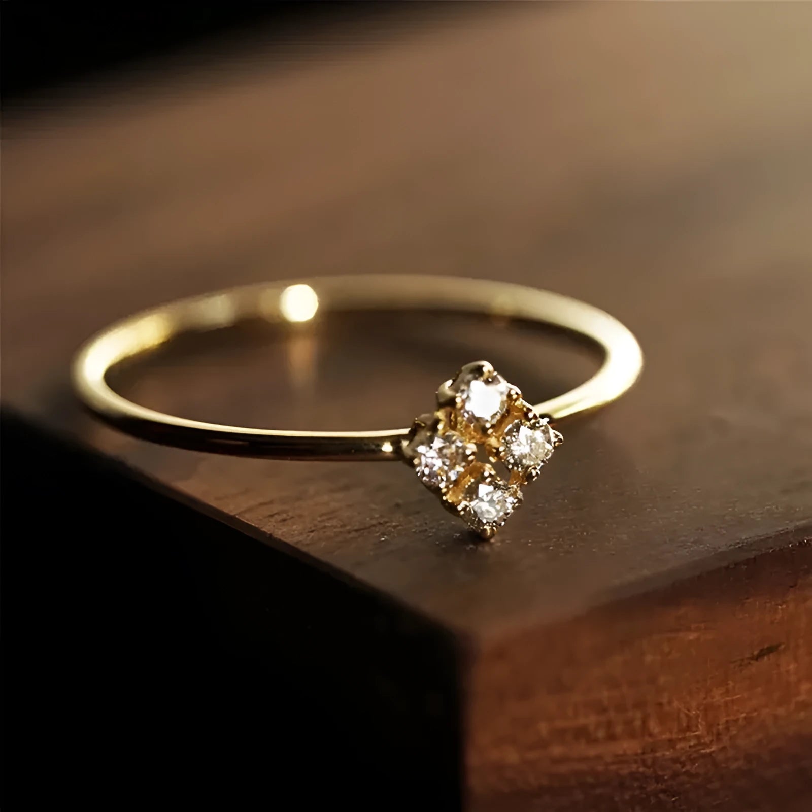 Four heart-shaped motif gold rings with zircon stones set on a dark surface