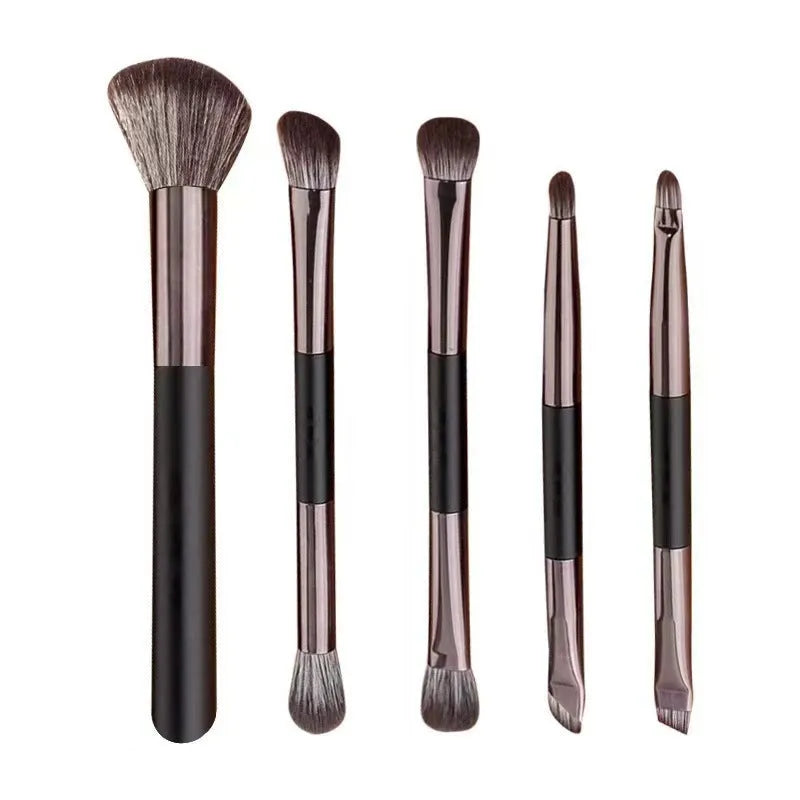 Portable makeup brush set with mirror showing gold or silver handled eyeshadow brushes.