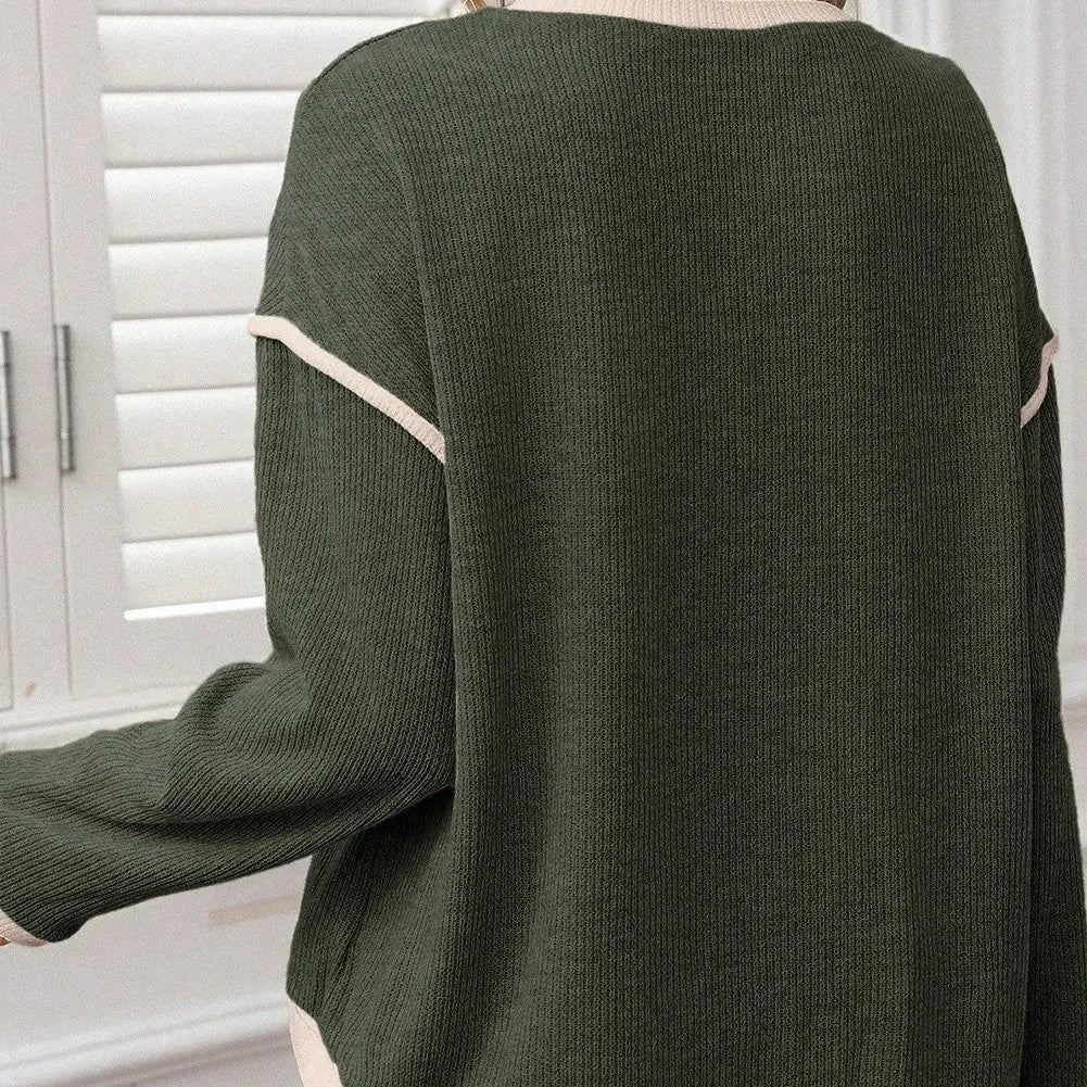 Women's loose grey knit top with green four leaf clover pattern trim on the sleeves and hem.
