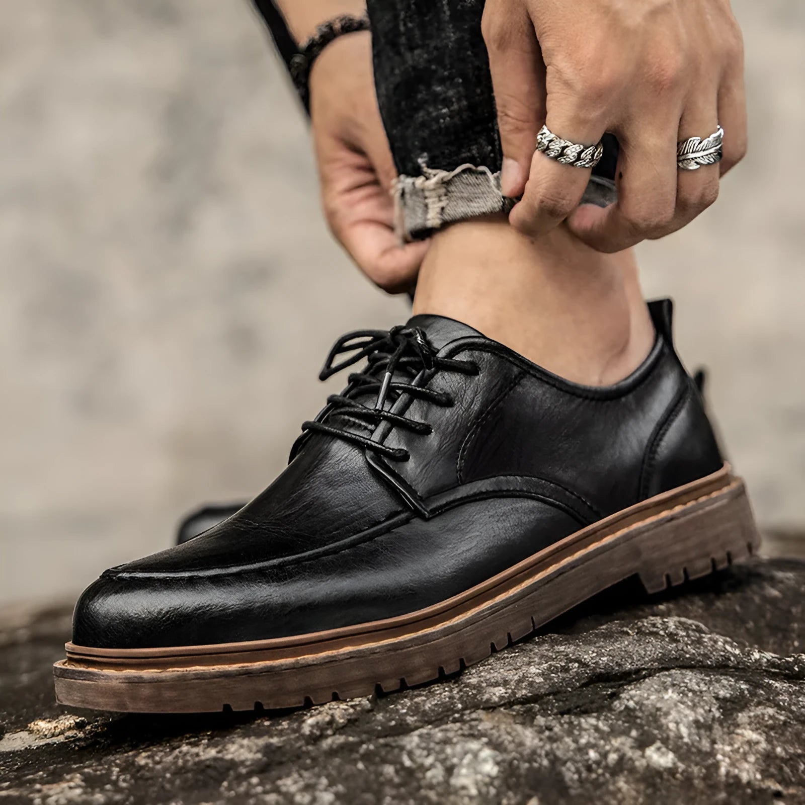 Men's black and brown casual leather slip-on shoes with round toe and visible sewing line detailing.