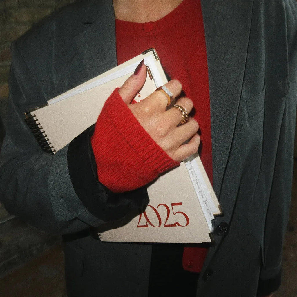 Cherry red A5 daily schedule coil notebook showing spiral binding and open pages