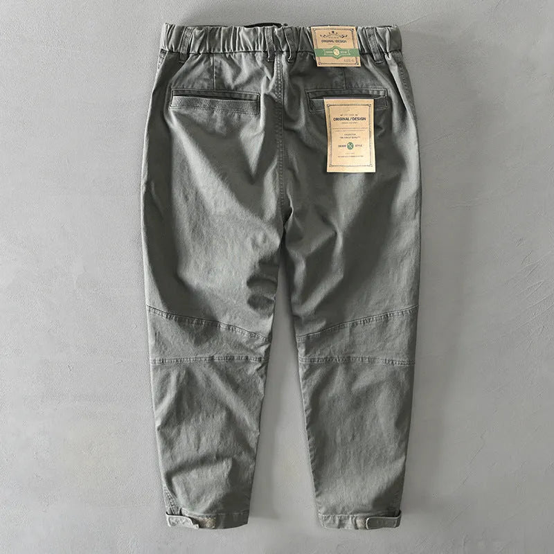 Man wearing khaki coloured loose fit cotton overalls with a mid waist design