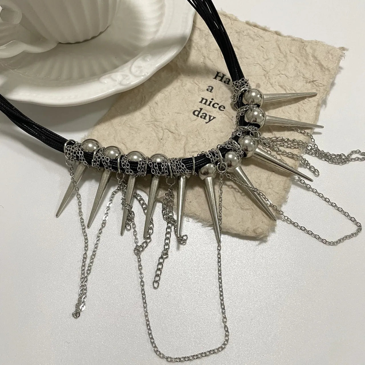 Women's rivet round beads winding tassel necklace with leather cord and electroplated brass accents.