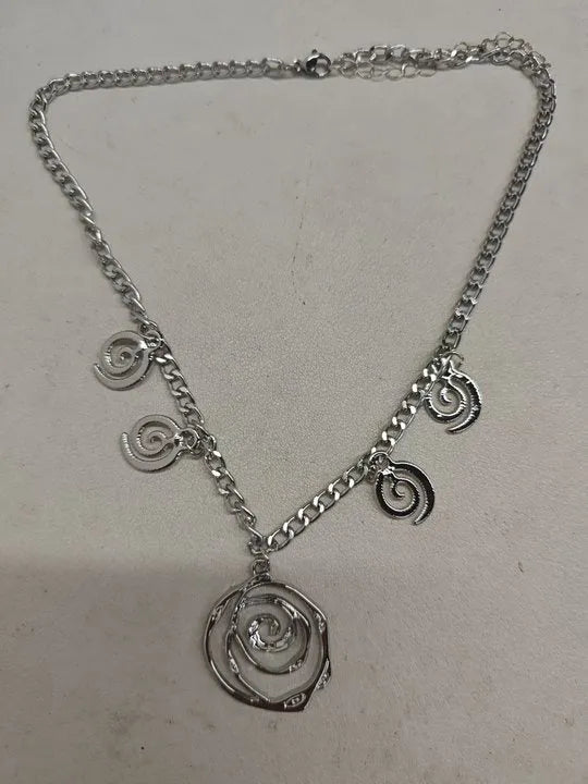 Women's spiral donut charm jewellery set with gold necklace, bracelet and earrings on white background