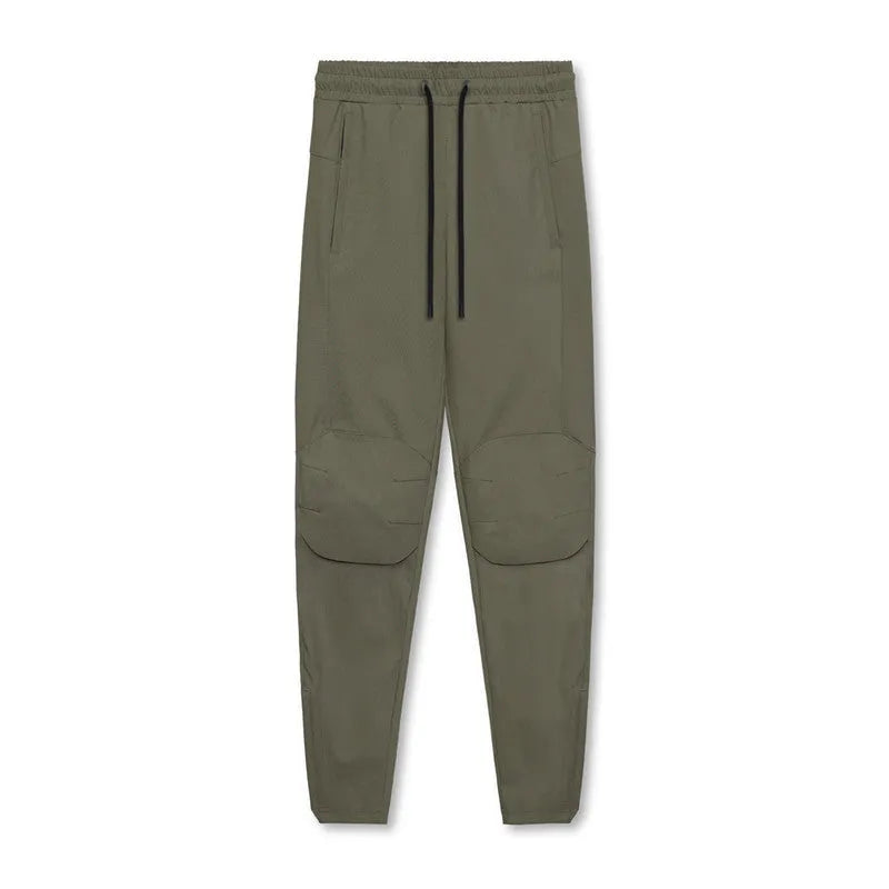 Man wearing dark grey loose-fit ankle-tied polyester running trousers for fitness.