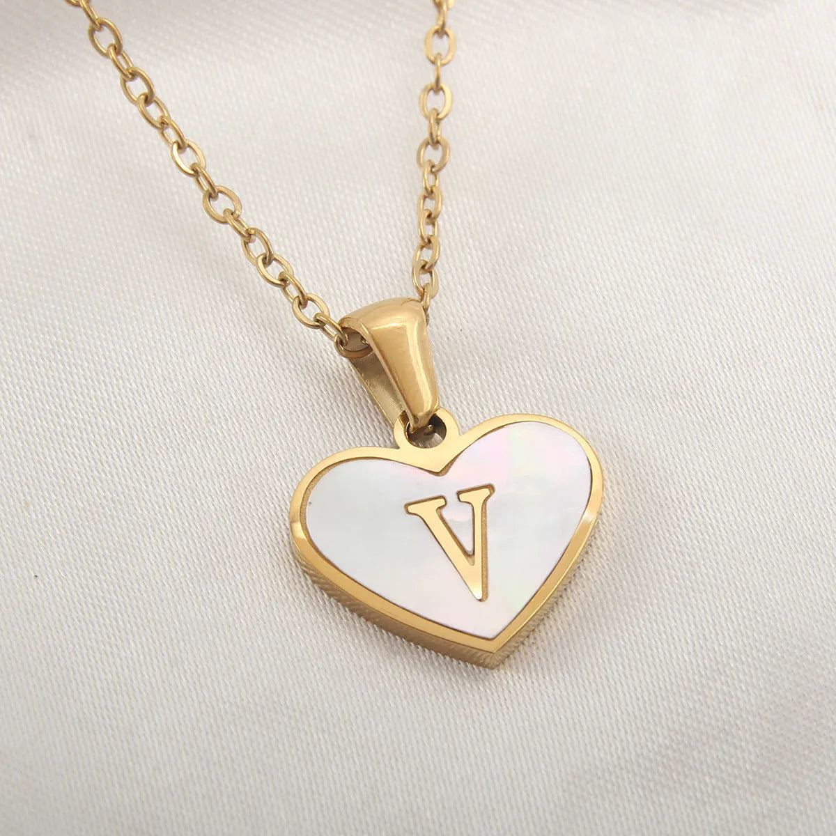 Gold plated heart-shaped necklace with a personalised initial letter and white shell detail on a 50cm adjustable chain.