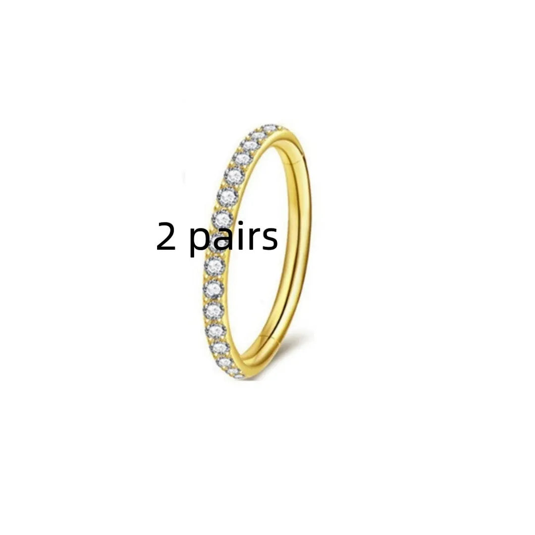 Two pairs of round, seamless 316 stainless steel nose rings showing black, gold, rose gold, and steel colour finishes.