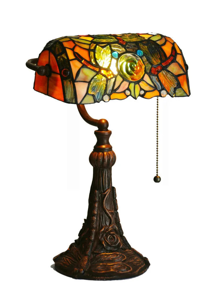 Tiffany table lamp with coloured glass lampshade and stained glass resin base on wooden desk