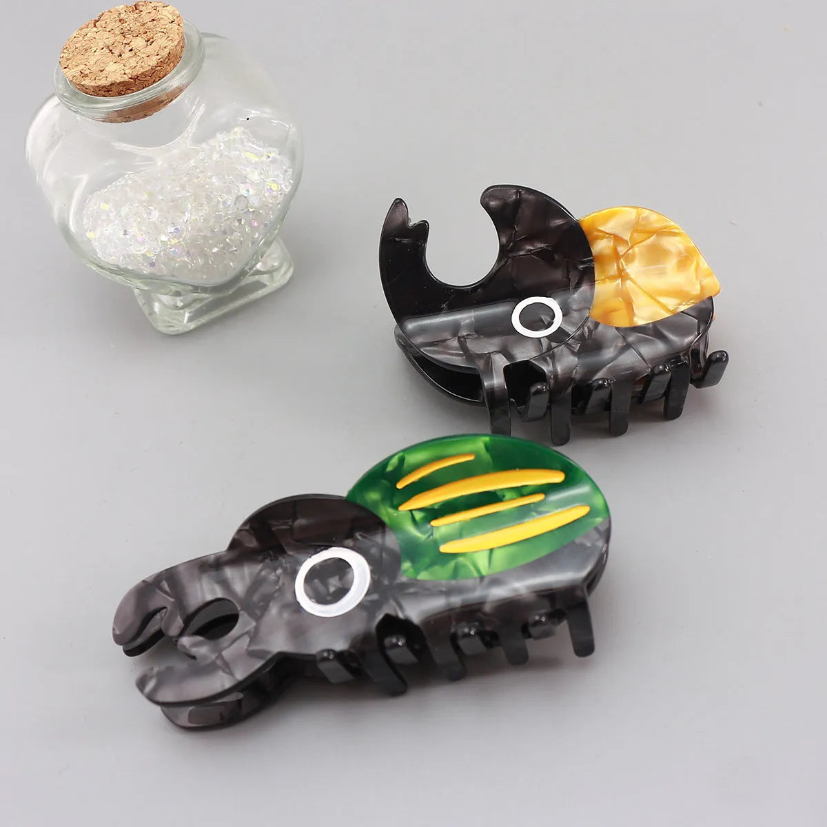 Handmade cellulose acetate beetle grip hair clip with cartoon caterpillar design in green, orange and white colours