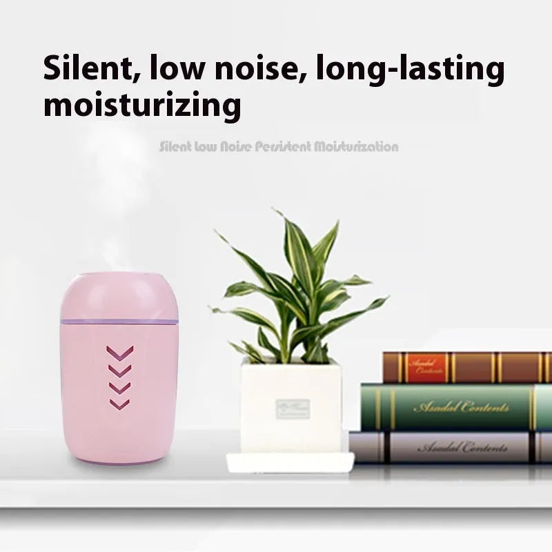 Round white portable air purifier with USB cable on a wooden desk.