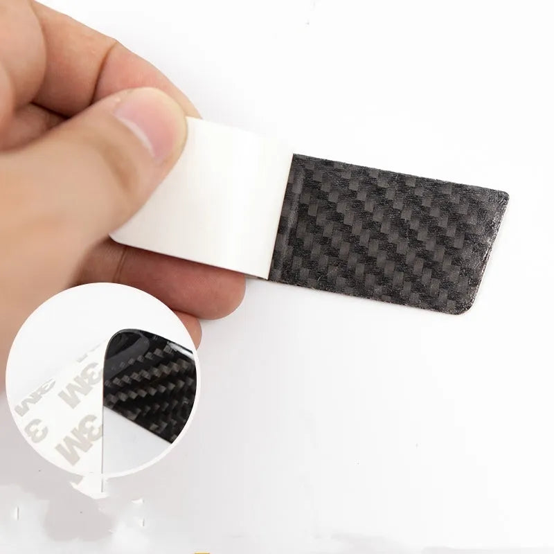 Four carbon fibre adhesive door handle protection patches for a Tesla Model S.