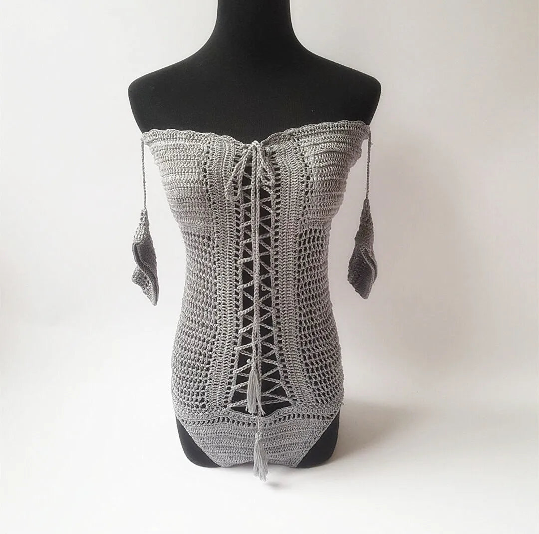 Women's off-shoulder one-piece swimsuit in light pink on a mannequin.