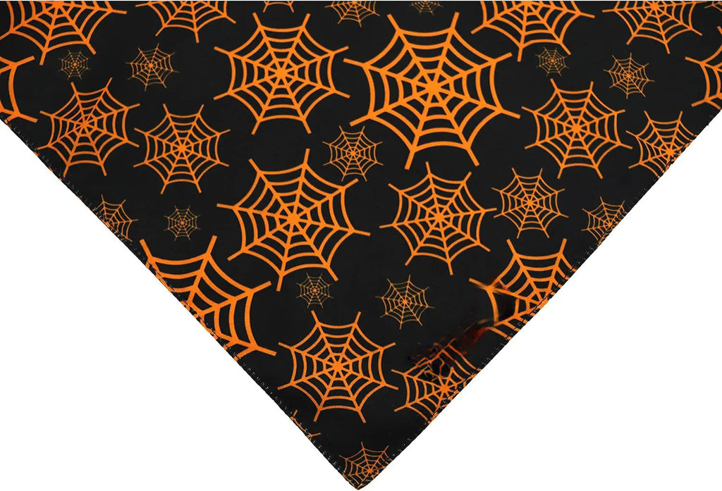 Black and orange reversible Halloween dog bandana with pumpkin and spider web patterns, showing adjustable neck strap.