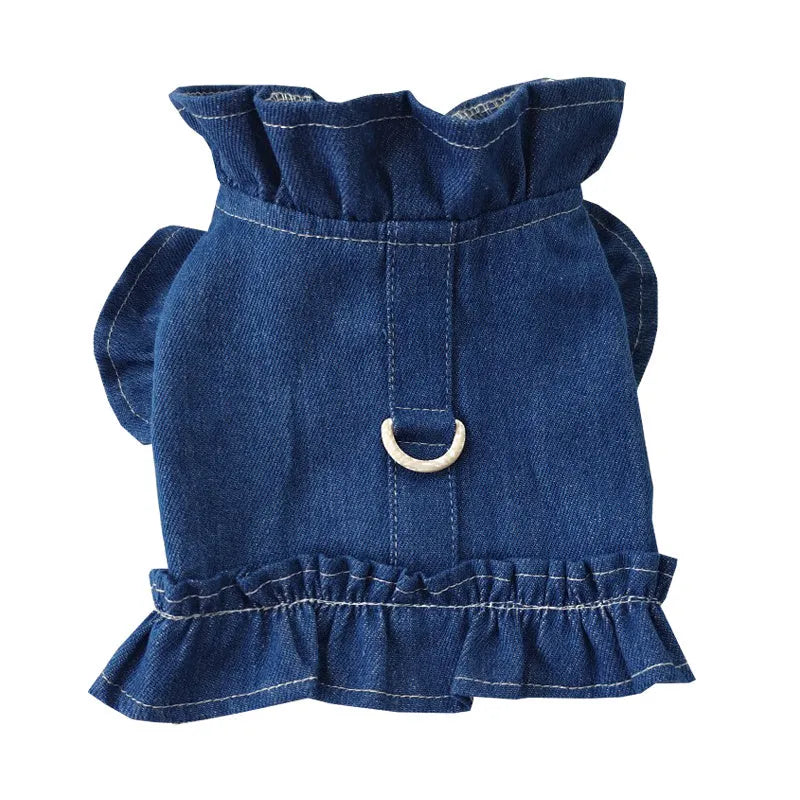 Blue denim dog dress with ruffle trim and metal leash attachment rings on chest and back