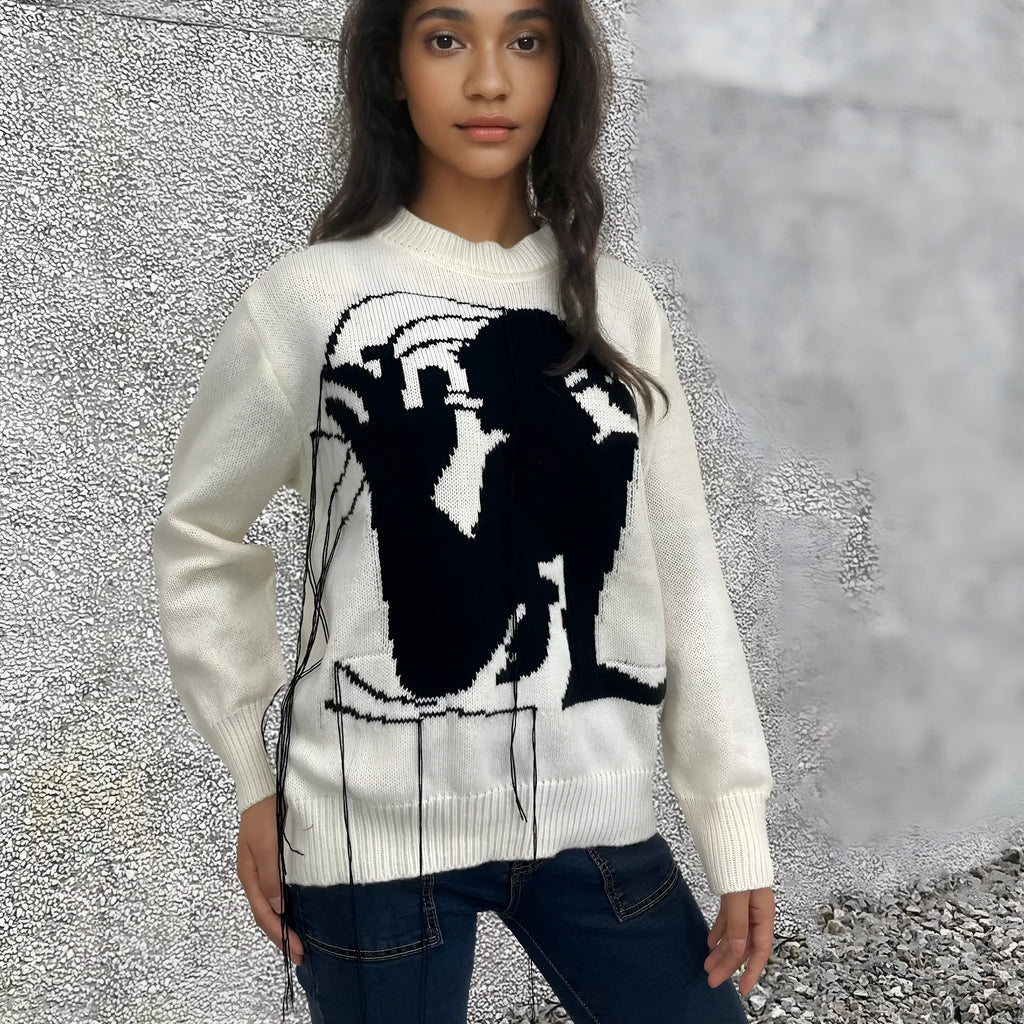 Grey women's loose alpaca wool sweater with abstract pattern and tassel design details on sleeve.