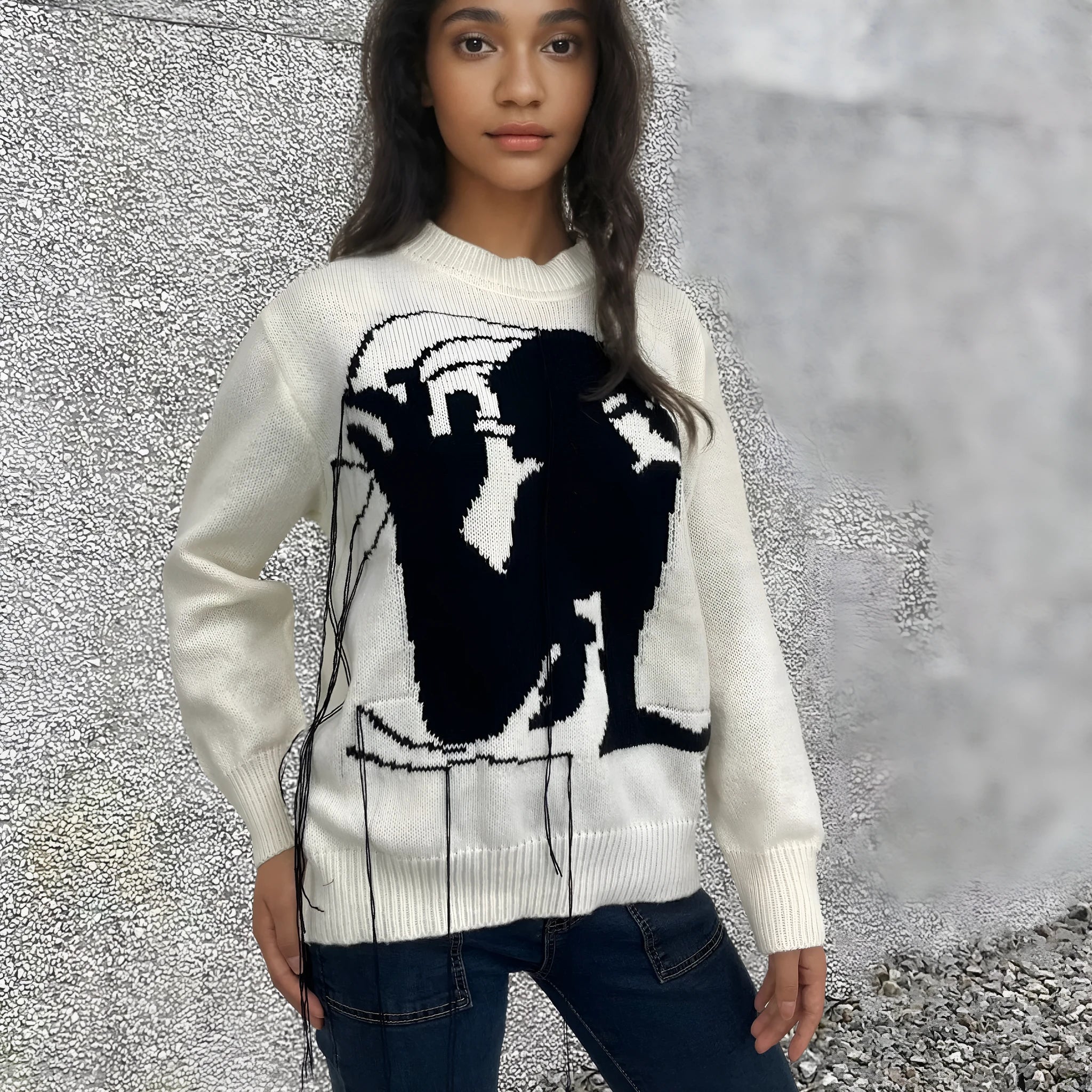 Grey women's loose alpaca wool sweater with abstract pattern and tassel design details on sleeve.