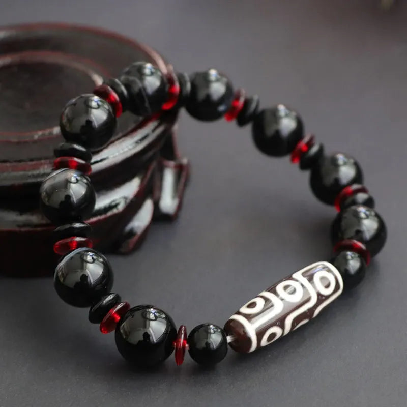 Hand-woven black agate dzi bead bracelet with geometric design measuring 11mm diameter
