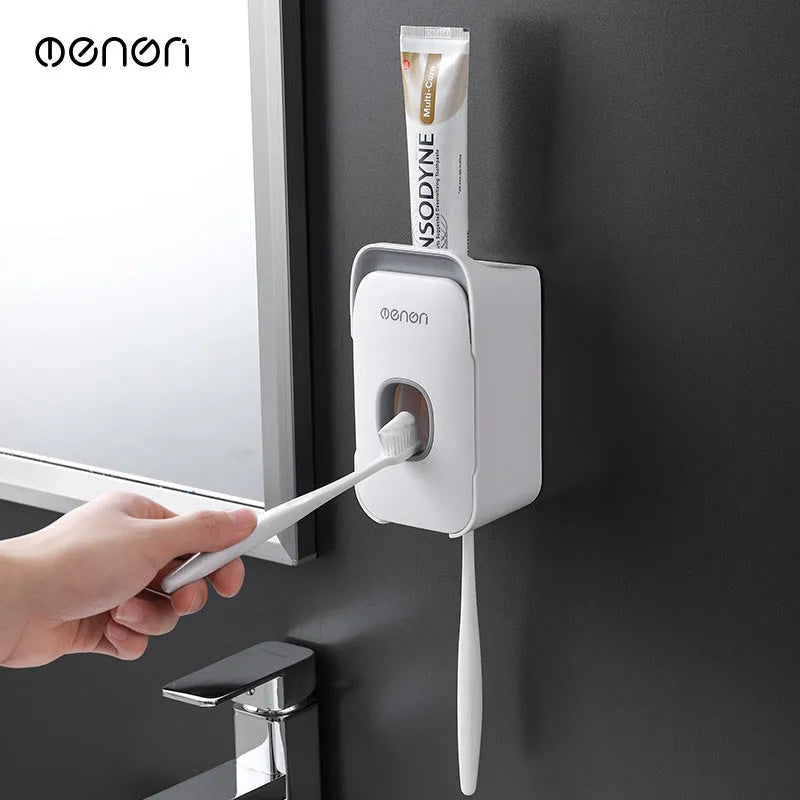 Blue automatic toothpaste dispenser mounted on a bathroom wall with a transparent window showing paste inside.