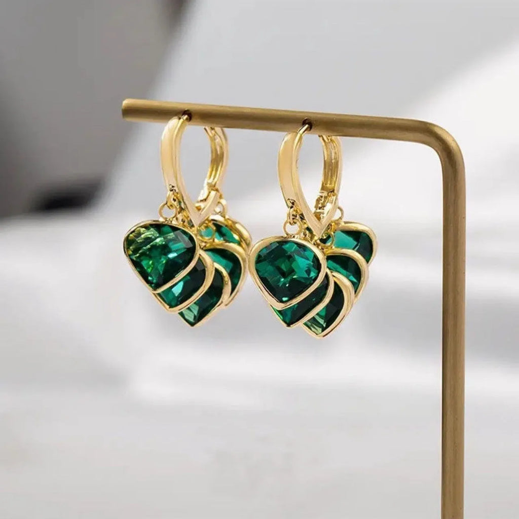 Green glass heart-shaped pendant on copper ear clip earrings with alloy inlay detail.