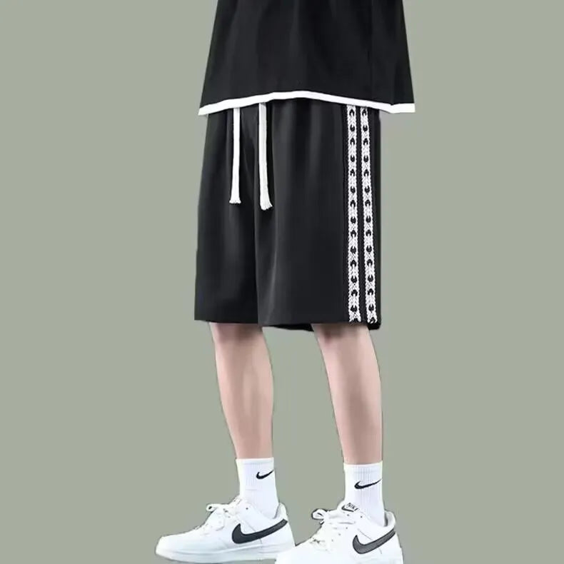 Men's black loose-fit track pants with elastic waistband and baggy leg silhouette