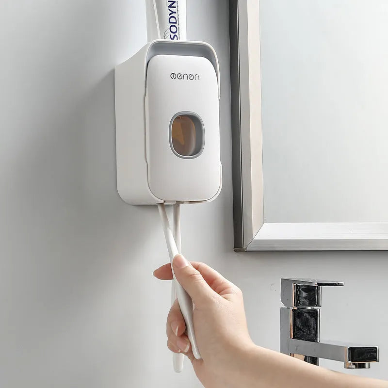 Blue automatic toothpaste dispenser mounted on a bathroom wall with a transparent window showing paste inside.