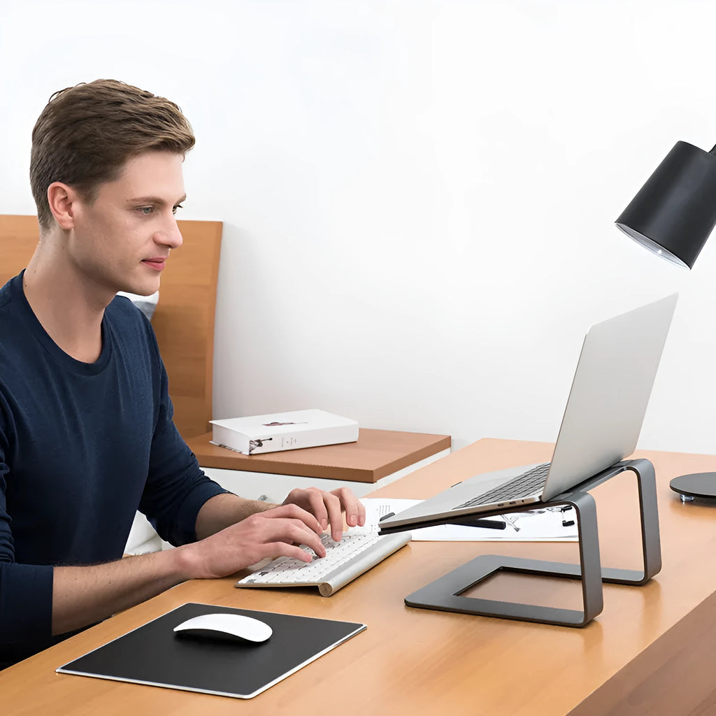 Black aluminium alloy foldable laptop stand with adjustable tilt on desktop
