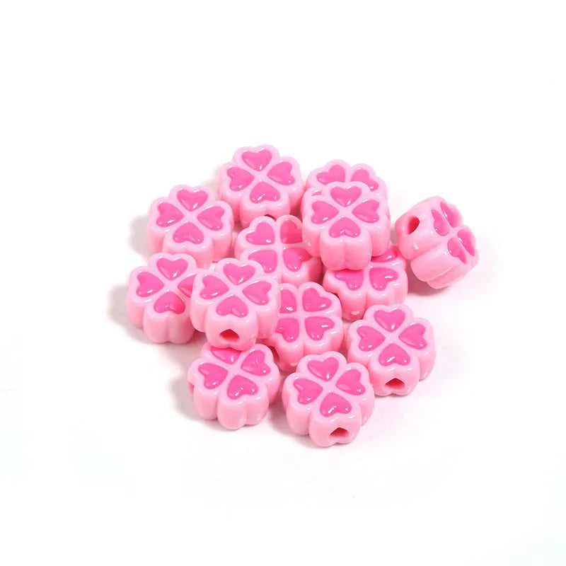 A selection of 15mm frosted acrylic beads showing a raised cartoon love and four-leaf clover pattern in various colours.