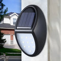 Black rectangular LED solar wall light mounted on an exterior wall for automatic night-time illumination.