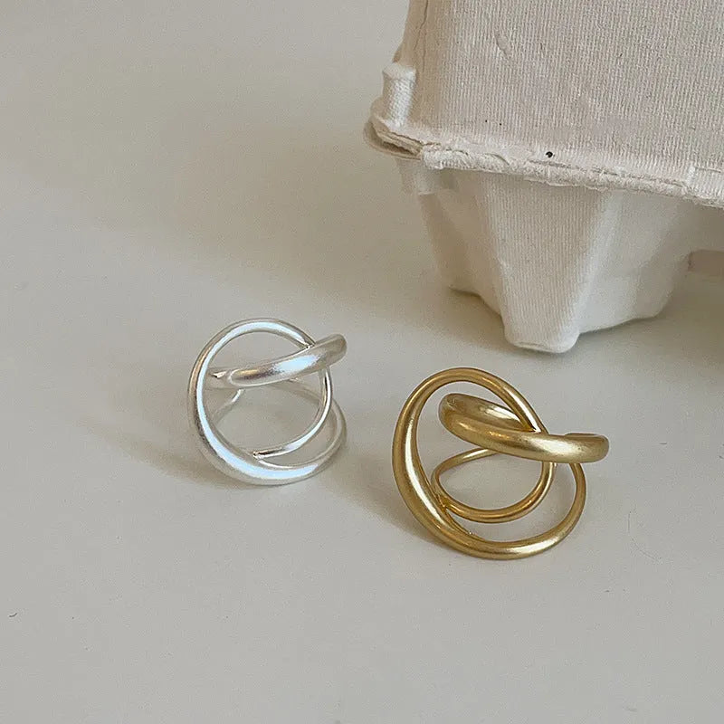 Geometric open ring with interlaced design in matte gold metal finish