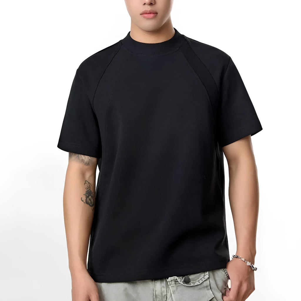 Man wearing a loose fit black short sleeve top with visible air layer stitching detail.