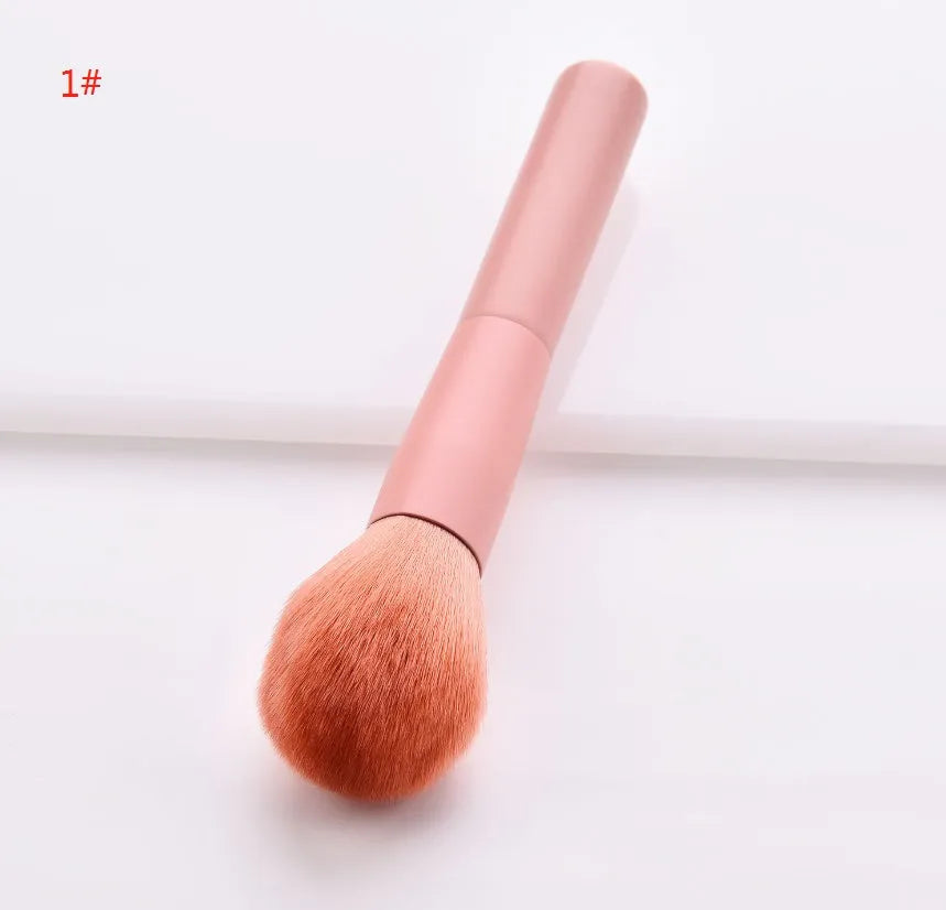 Ten cosmetic makeup brushes with wooden handles arranged showing various brush head shapes and sizes