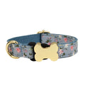 Flat nylon dog collar with grid print and a silver bone-shaped metal buckle on a green background.